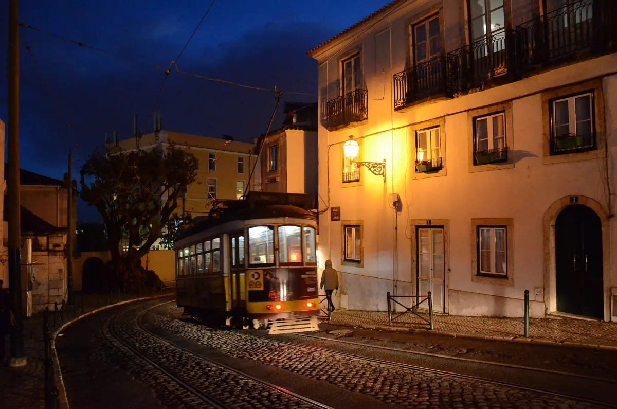 A tram on a steep street in Alfama in the evening